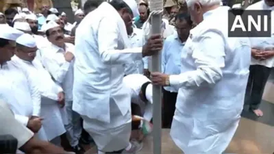 outrage erupts as congress leader removes siddaramaiah s shoes while holding tricolour